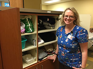 Nurse Joanne Middleton stands in front of the clothing closet